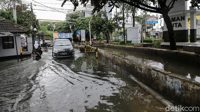 Nekat Terjang Banjir di Depok, Taksi Online Tenggelam Hingga Hanya Tinggal Atap